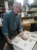 Lee Taylor searching an old copy of the Springville Herald